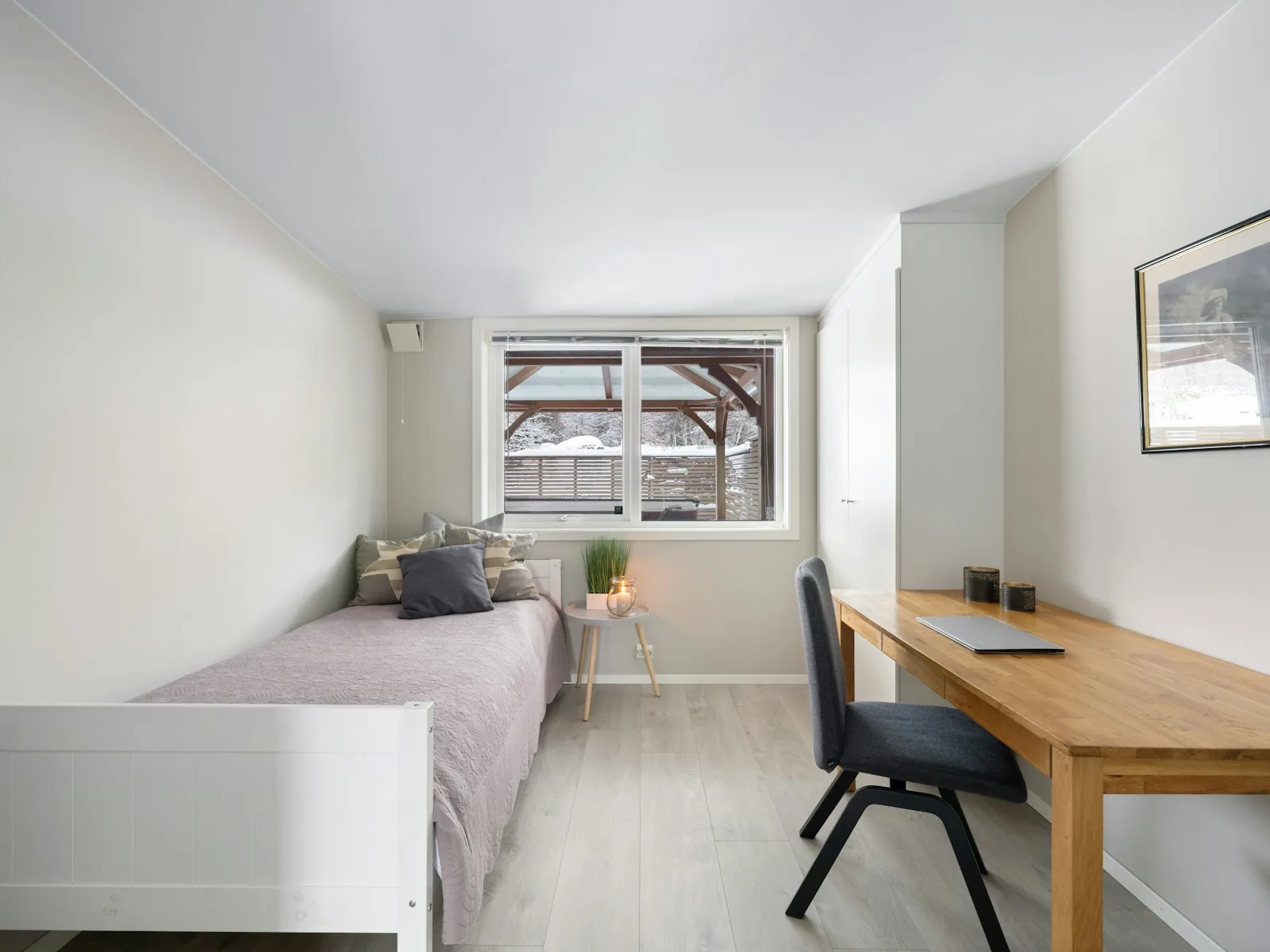Helles möbliertes Zimmer mit Bett, Schreibtisch und Fenster